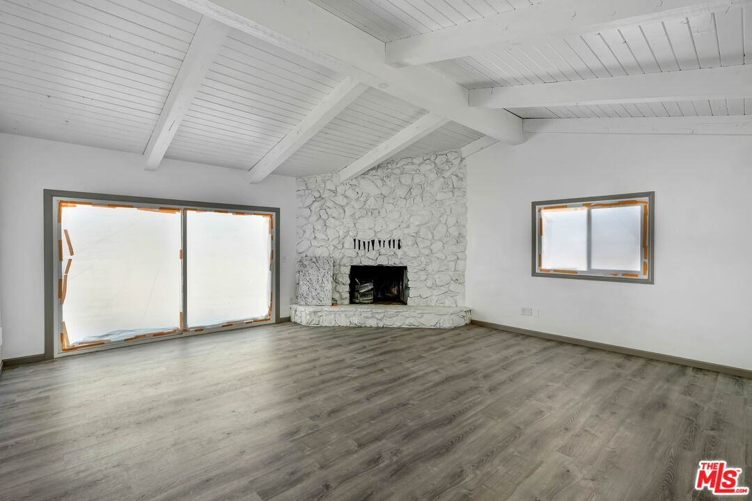 37170 Rabbit Springs Road Lucerne Valley, CA 92356 - Photo 6 of 10 an empty room with wooden floor and a fireplace