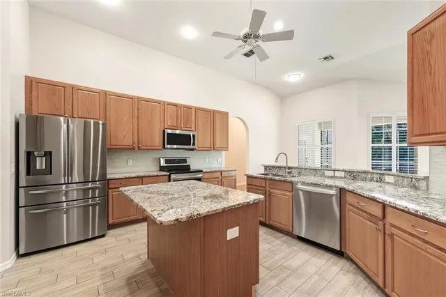a kitchen with stainless steel appliances granite countertop a sink stove and refrigerator