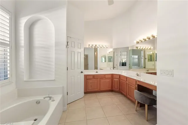 a large bathroom with a tub sink and mirror