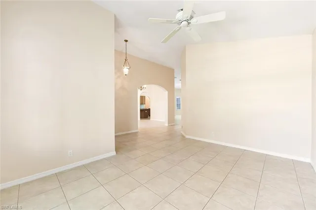 an empty room with white walls and ceiling fan