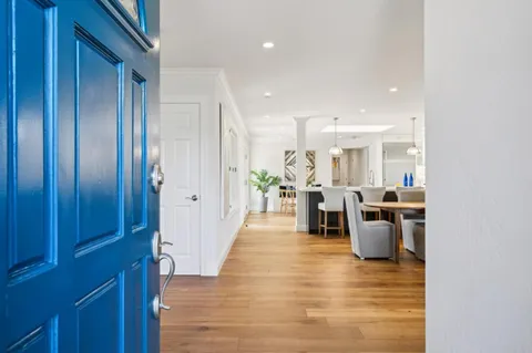 a view of a living room kitchen with furniture and a wooden floor