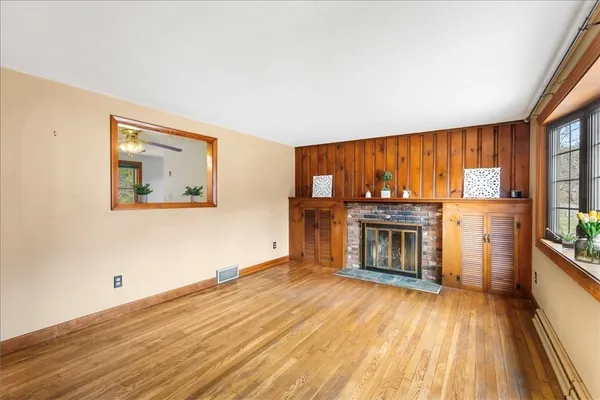 wooden floor fireplace and windows in an empty room