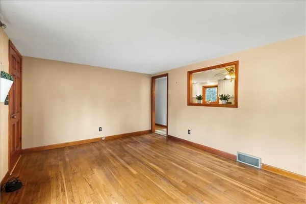 a view of empty room with wooden floor