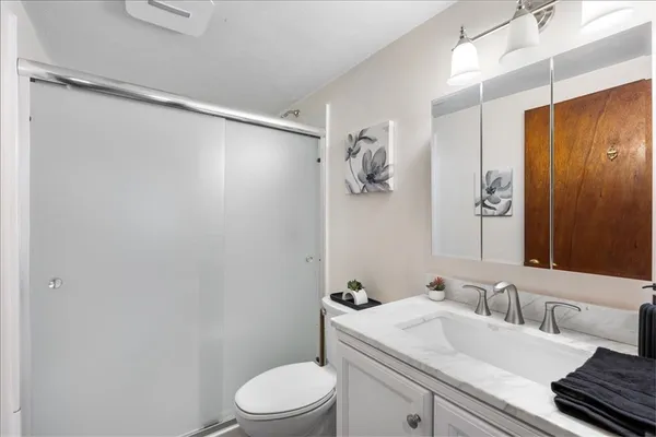a bathroom with a sink vanity mirror and toilet