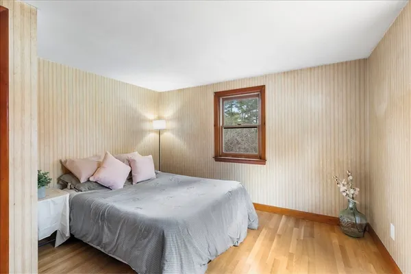 a bedroom with a bed and wooden floor