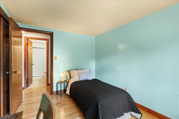 a bedroom with a bed and wooden floor