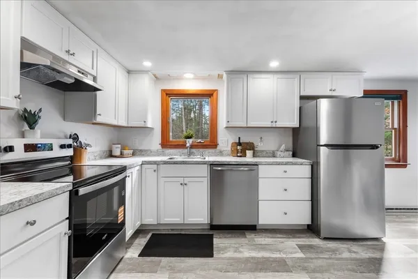 a kitchen with white cabinets and white appliances