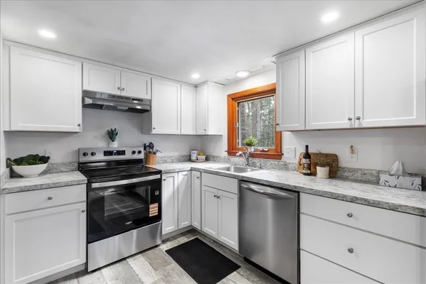 a kitchen with granite countertop white cabinets and white appliances