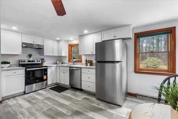 a kitchen with white cabinets and white appliances