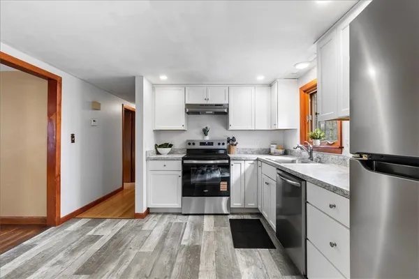 a kitchen with a refrigerator sink and cabinets