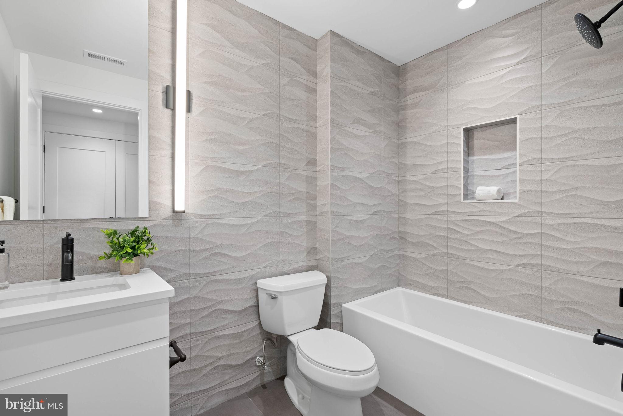 650 Fairmount Avenue, Unit I3 Philadelphia, PA 19123 - Photo 25 of 42 a bathroom with a granite countertop toilet a sink and a bathtub