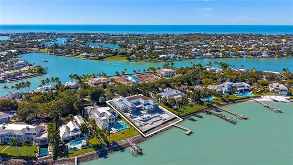 an aerial view of a city with lots of residential buildings and ocean view in back