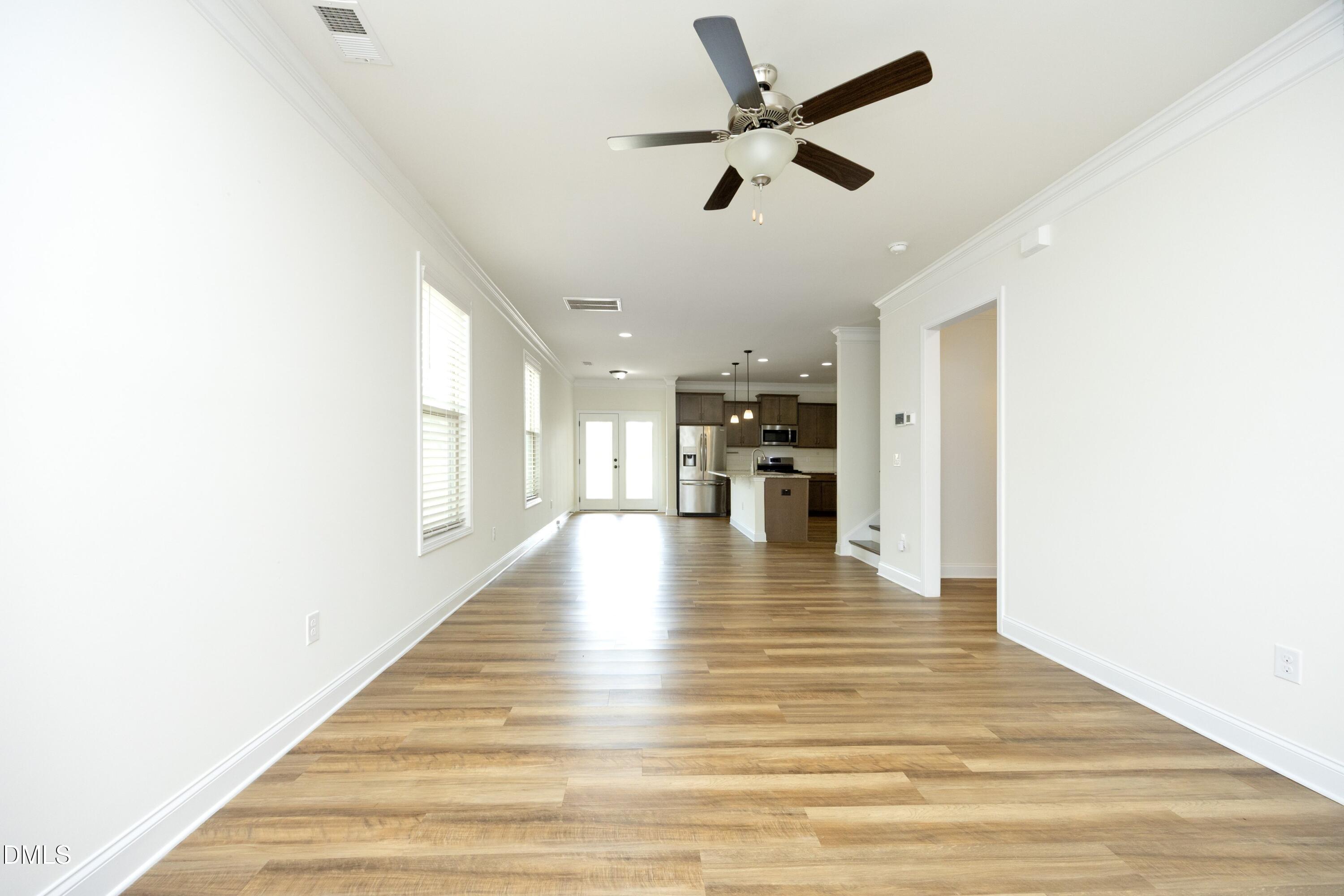 824 Country Downs Road Wake Forest, NC 27587 - Photo 11 of 41 a view of an empty room with wooden floor and a ceiling fan