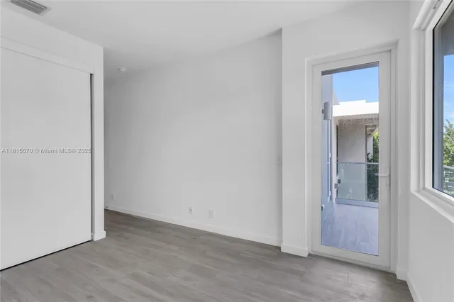 a view of an empty room with wooden floor