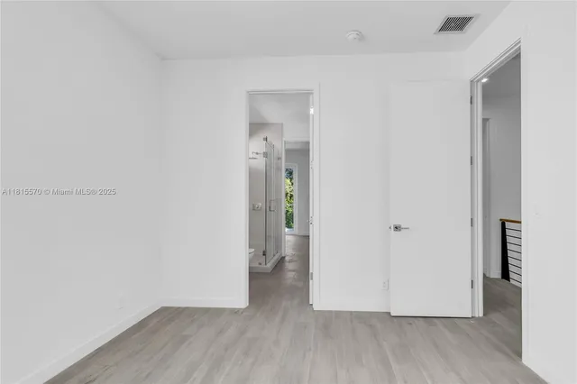 an empty room with wooden floor and a window