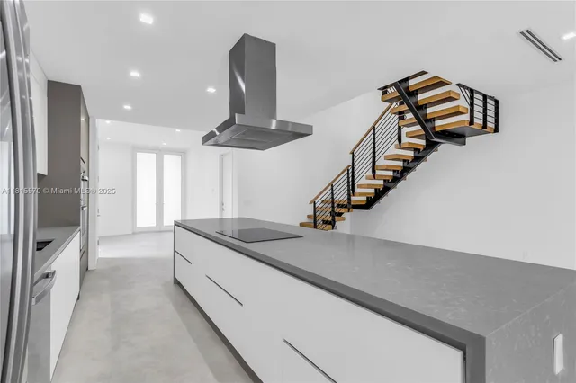 a kitchen with stainless steel appliances granite countertop a sink and a refrigerator