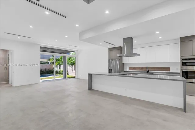 a large kitchen with stainless steel appliances a large counter top