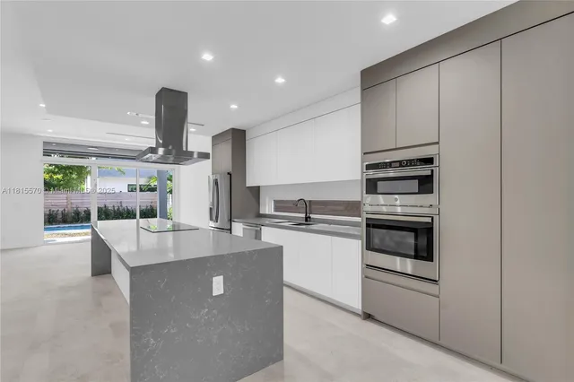 a kitchen with stainless steel appliances kitchen island granite countertop a sink and stove top oven