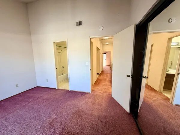 an empty room with wooden floor and a bathroom