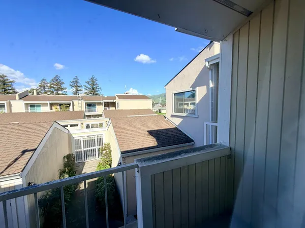 a view of an empty room with a chandelier fan and a window