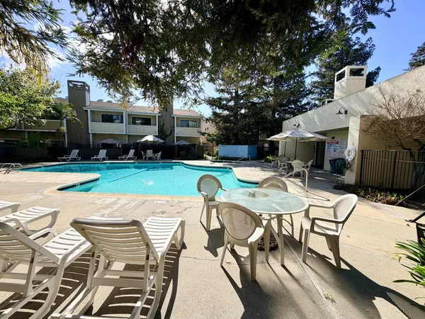 a view of a swimming pool with a patio and a yard