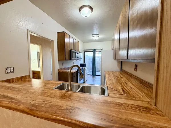 a kitchen with stainless steel appliances kitchen island granite countertop a refrigerator and a sink