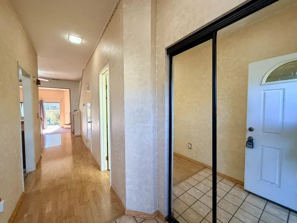 a view of a hallway with wooden floor and a cabinet