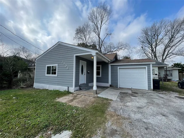 a view of a house with a yard and pathway