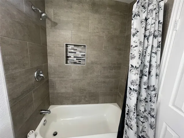 a bathroom with a bathtub and shower