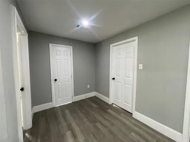 a view of an empty room and wooden floor