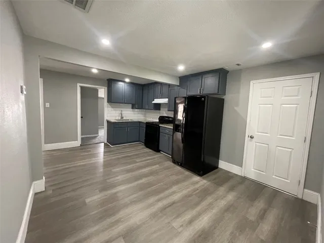 a view of kitchen with refrigerator microwave and cabinets