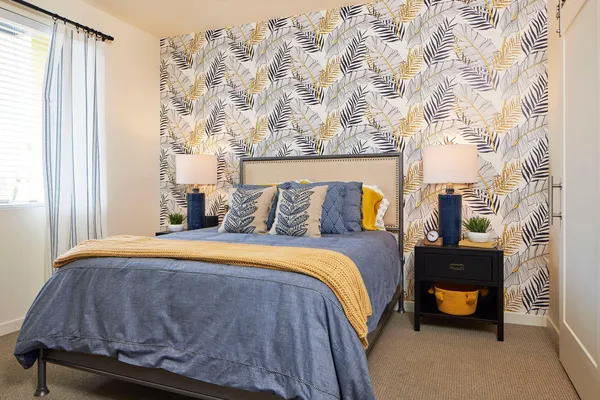 a bedroom with a bed and a lamp next to a window