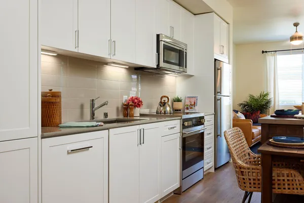 a kitchen with stainless steel appliances white cabinets and a sink
