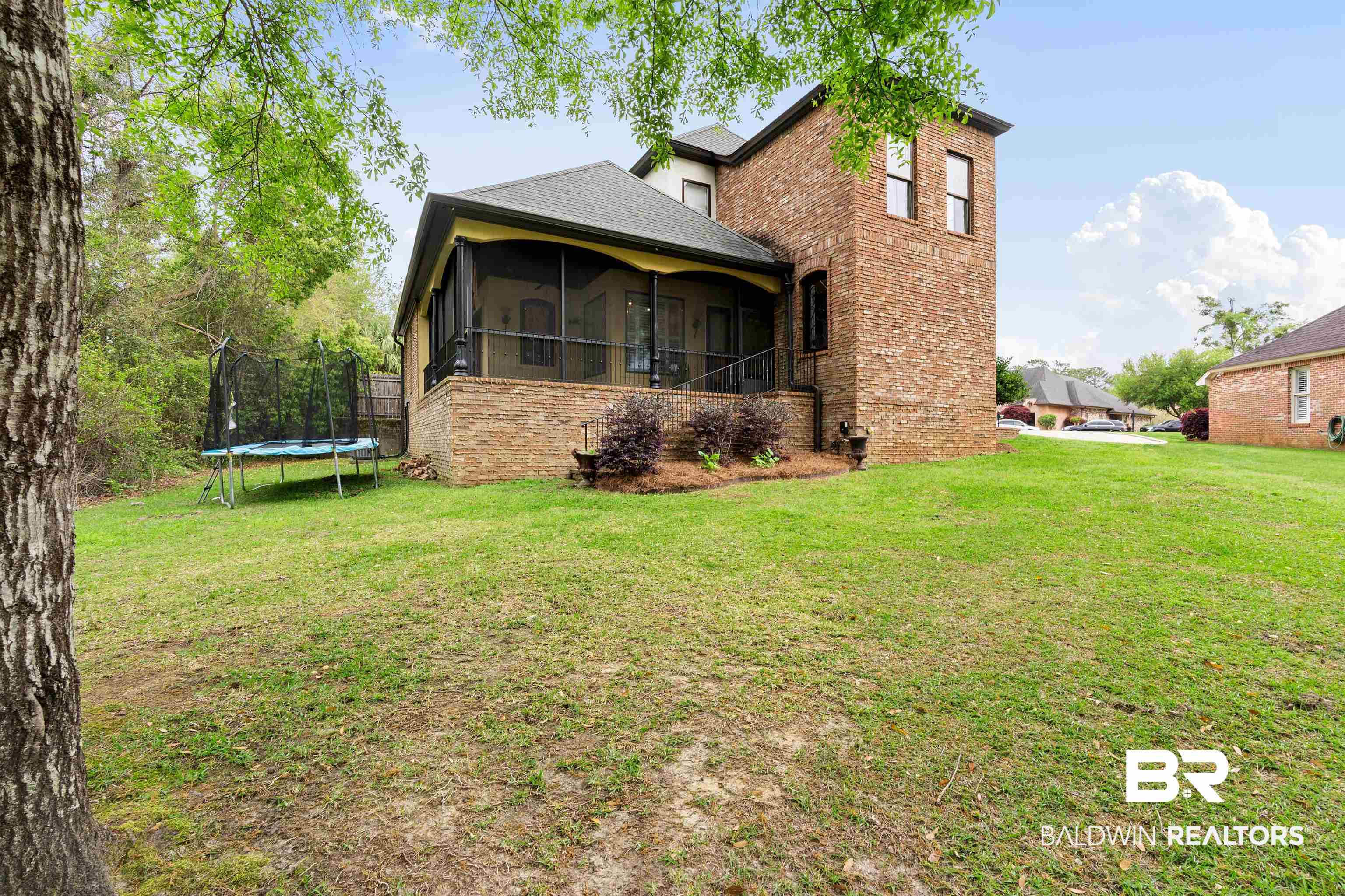 3584 Rue Royal Mobile, AL 36693 - Photo 33 of 35 Back of property with a yard, a trampoline, brick siding, and a sunroom