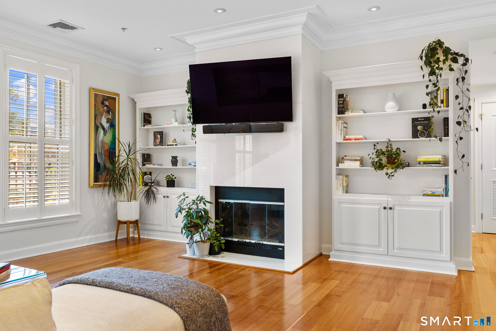 85 Memorial Road, Unit 205 West Hartford, CT 06107 - Photo 14 of 40 a living room with a fireplace a flat screen tv and a window