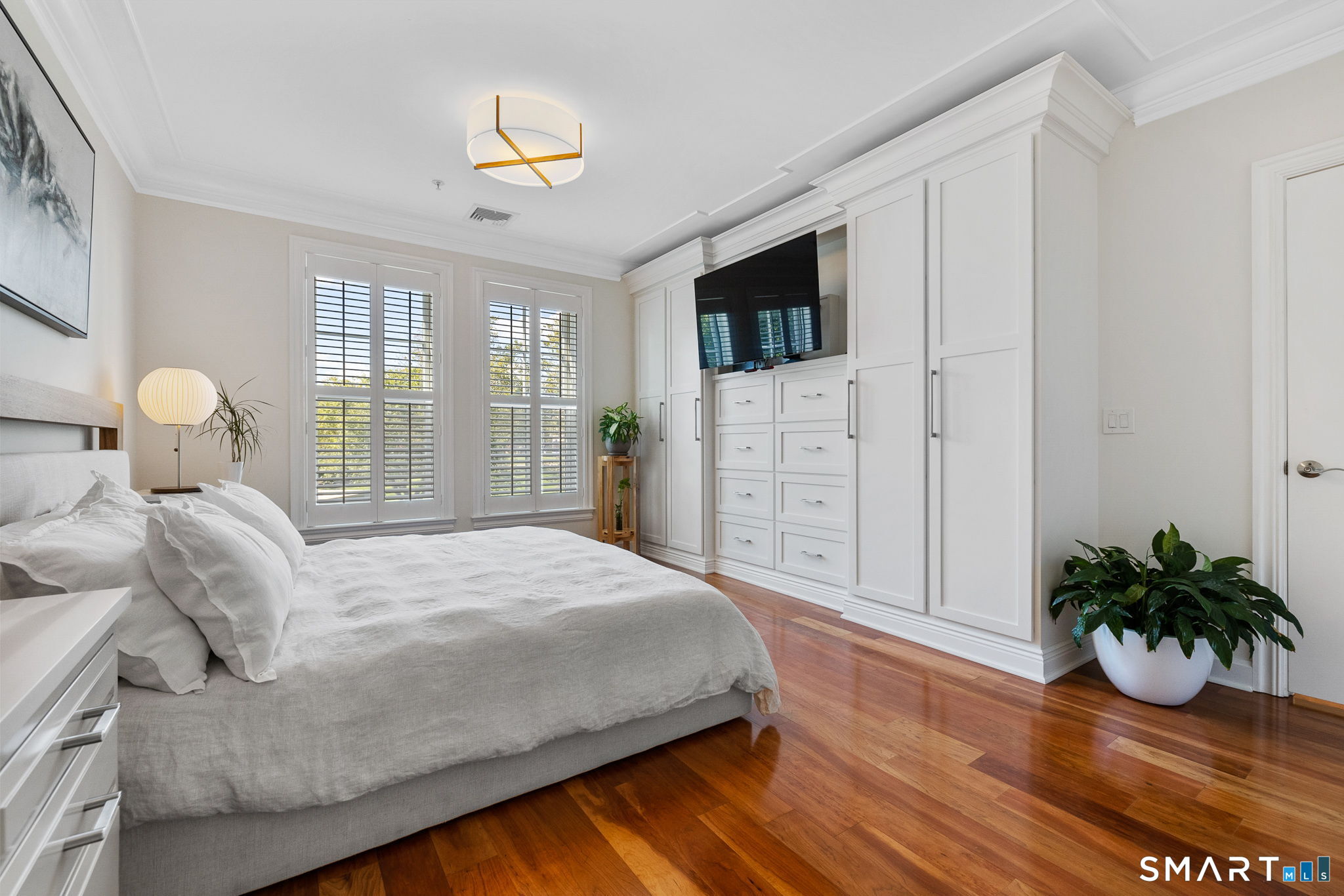 85 Memorial Road, Unit 205 West Hartford, CT 06107 - Photo 17 of 40 a bedroom with a bed and wooden floor