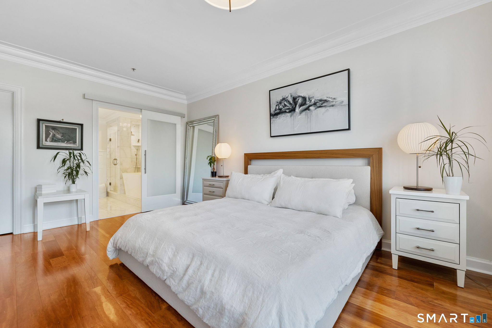 85 Memorial Road, Unit 205 West Hartford, CT 06107 - Photo 18 of 40 a bedroom with a bed and wooden floor