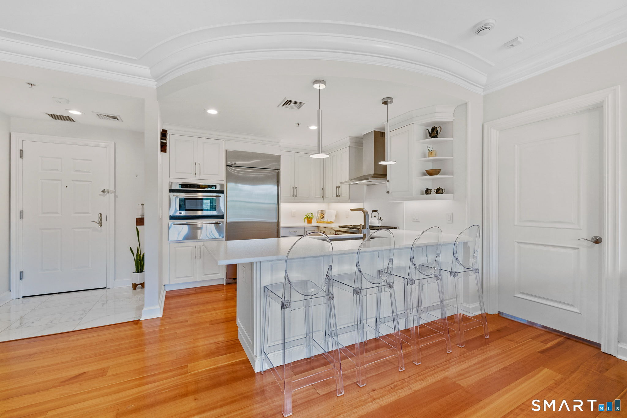 85 Memorial Road, Unit 205 West Hartford, CT 06107 - Photo 3 of 40 a large white kitchen with kitchen island a sink a center island stainless steel appliances and a cabinets