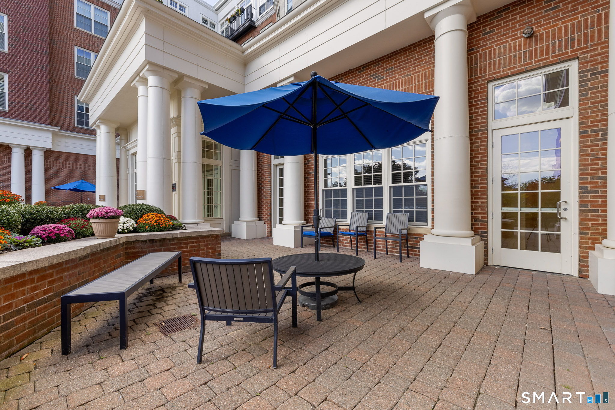 85 Memorial Road, Unit 205 West Hartford, CT 06107 - Photo 37 of 40 a view of a dinning table and chairs in the patio