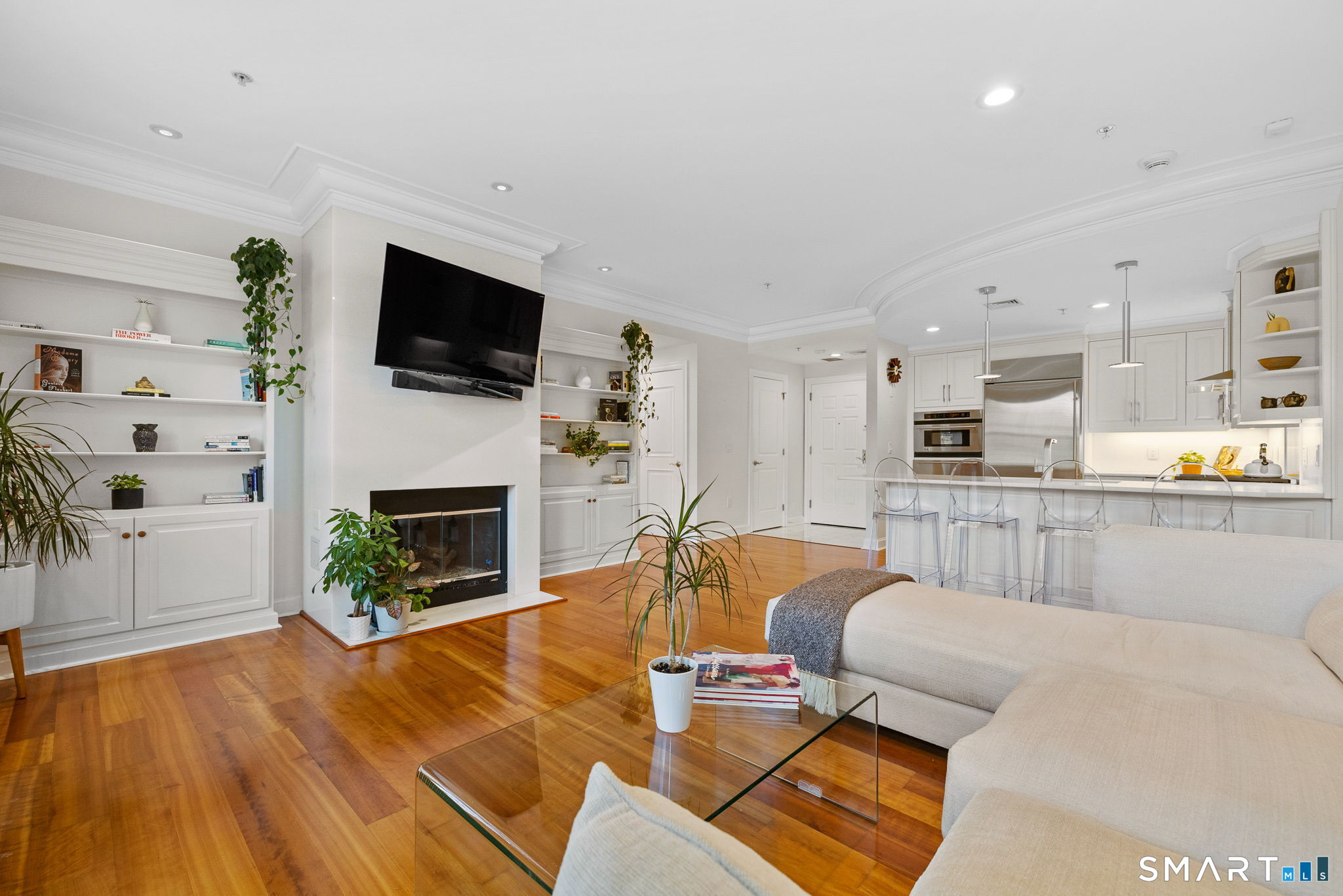 85 Memorial Road, Unit 205 West Hartford, CT 06107 - Photo 10 of 40 a living room with furniture a fireplace and a flat screen tv