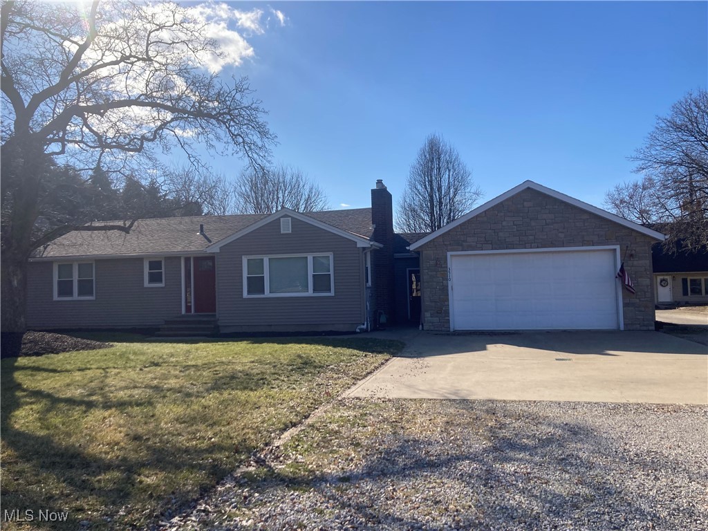 3510 Long Road Avon, OH 44011 - Photo 1 of 26 Ranch-style home with an attached garage, a chimney, concrete driveway, a front yard, and a shingled roof