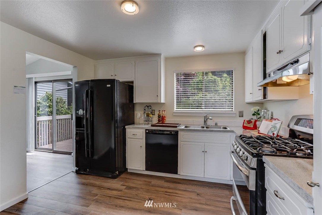 2805 Northeast 23rd Place Renton, WA 98056 - Photo 8 of 27 a kitchen with stainless steel appliances granite countertop a refrigerator stove and sink