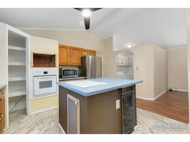 a kitchen with stainless steel appliances kitchen island a refrigerator sink and cabinets