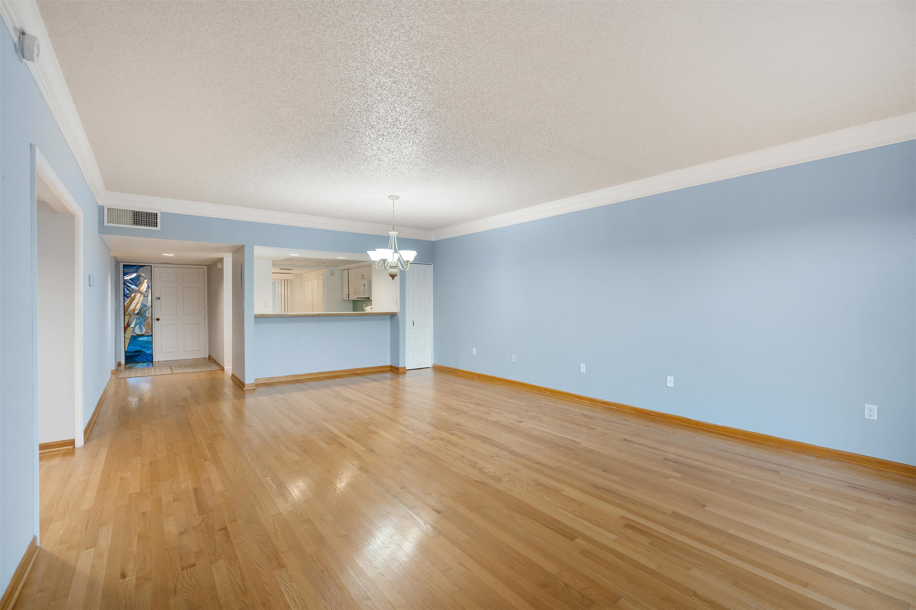 20 Dondanville Road, Unit A302 St. Augustine, FL 32080 - Photo 8 of 43 a view of an empty room with wooden floor and kitchen