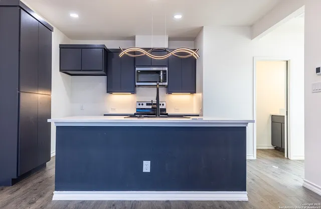 a kitchen with a sink and wooden floor