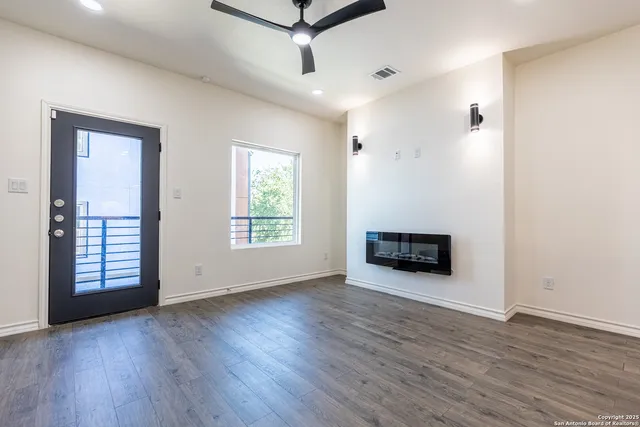an empty room with wooden floor and windows