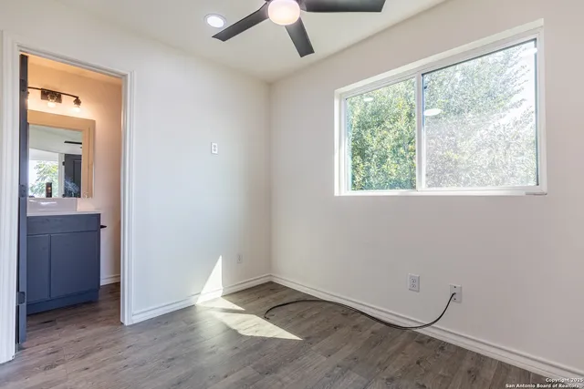 a view of an empty room with wooden floor and closet