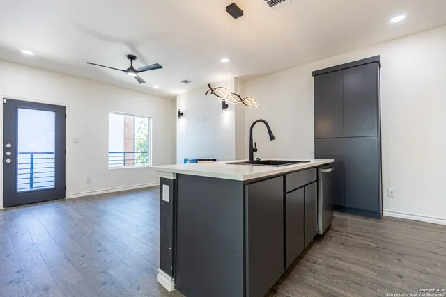 a kitchen with kitchen island granite countertop a sink stove and refrigerator