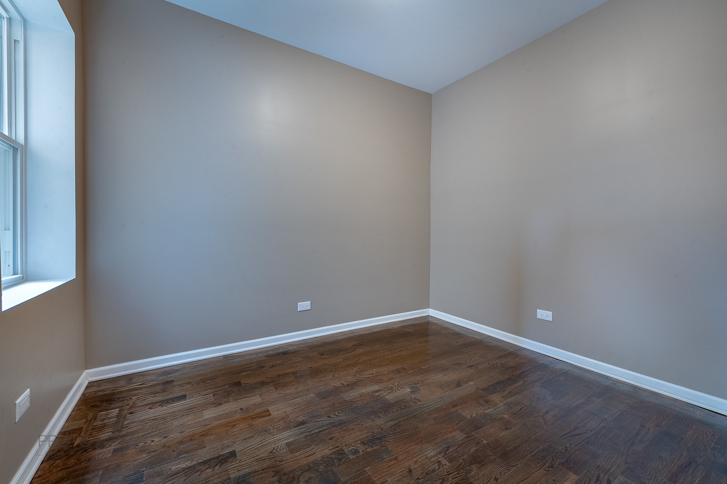 35 North Mayfield Avenue, Unit 2 Chicago, IL 60644 - Photo 13 of 15 a view of an empty room with wooden floor and a window