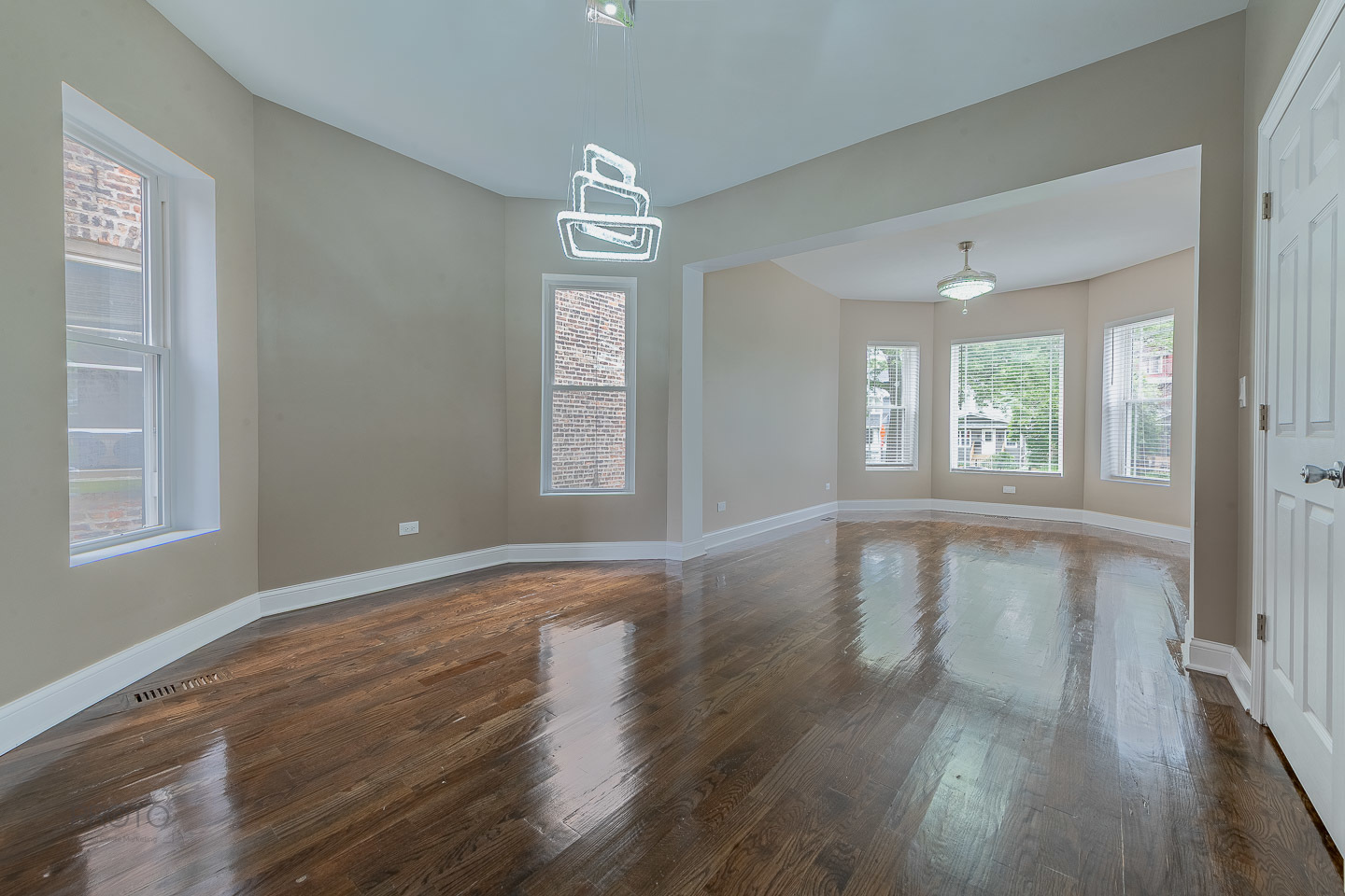 35 North Mayfield Avenue, Unit 2 Chicago, IL 60644 - Photo 3 of 15 a view of an empty room with wooden floor and a window